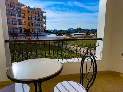 a table and chairs on a balcony with a view at Nile view Apartment in Luxor