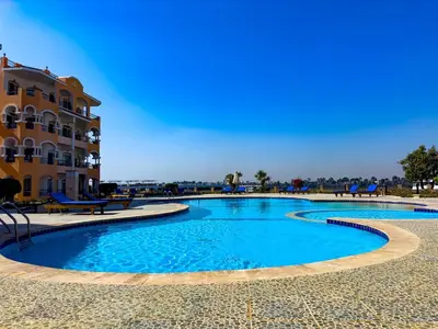 a large swimming pool in front of a building at Nile view Apartment in Luxor