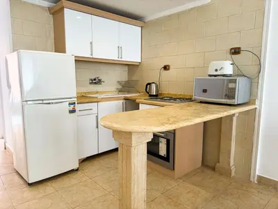 a kitchen with a white refrigerator and a counter at Nile view Apartment in Luxor
