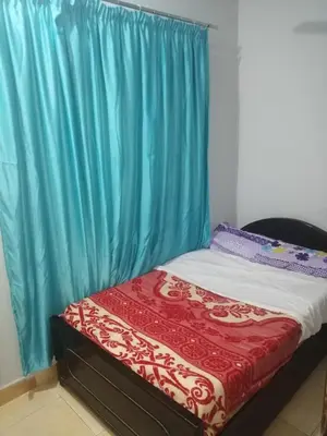 a bed in a room with a blue curtain at Al Dahar apartments Hurghada in Hurghada