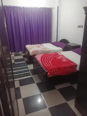 two beds in a room with purple curtains at Al Dahar apartments Hurghada in Hurghada
