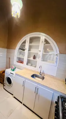 a kitchen with a sink and an arched window at Nubian House in Al Aqālitah
