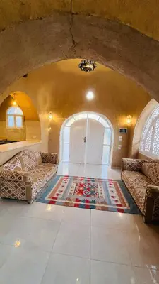 a living room with two couches and a door at Nubian House in Al Aqālitah