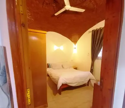 a bedroom with a bed with a ceiling fan at Upper Egypt House in Luxor
