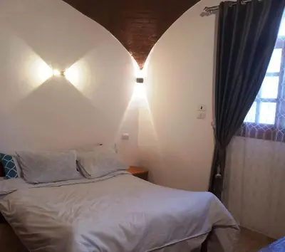 a bedroom with a bed and a window and lights at Upper Egypt House in Luxor