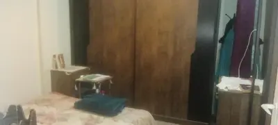 a bedroom with a bed and a wooden closet at شقه ب موقع متميز عل النيل in Maḩaţţat ash Shallāl