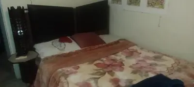 a small bedroom with a bed with a floral blanket at شقه ب موقع متميز عل النيل in Maḩaţţat ash Shallāl