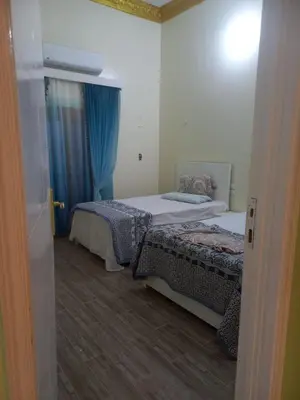 a hotel room with two beds and a window at Nile House Anis & Do in Luxor
