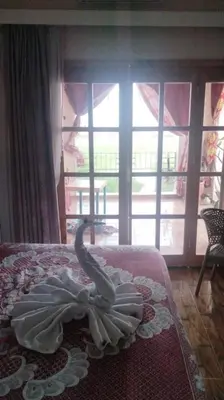 a swan decoration on a bed in front of a window at Nile House Anis & Do in Luxor