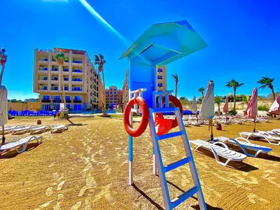 a beach with lounge chairs and a lifeguard tower at Juliana Beach in Hurghada