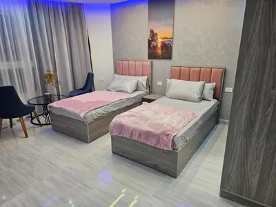 a room with two beds and a table at قرية الهمبرا السياحية بالغردقة in Hurghada