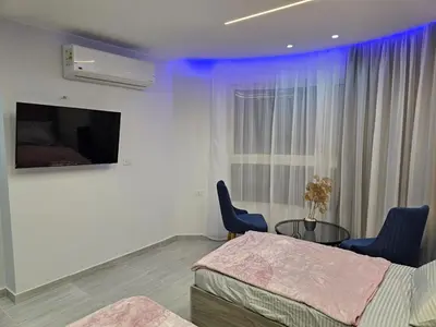 a bedroom with a bed and a table and a tv at قرية الهمبرا السياحية بالغردقة in Hurghada
