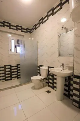 a bathroom with a toilet and a sink at Villa Abo Tarek in Al Aqālitah