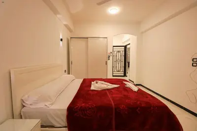 a bedroom with a bed with a red blanket at Villa Abo Tarek in Al Aqālitah