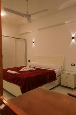 a bedroom with a bed and a ceiling fan at Villa Abo Tarek in Al Aqālitah