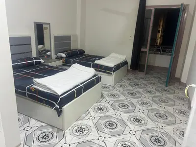 two beds in a room with a tiled floor at Dream apartment3 in Hurghada