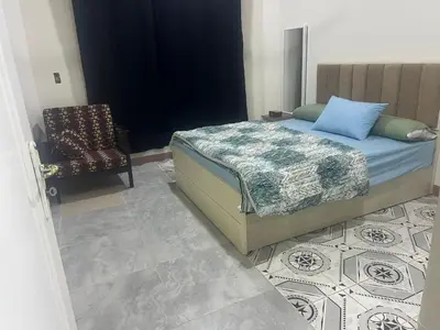 a bedroom with a bed and a chair at Dream apartment3 in Hurghada