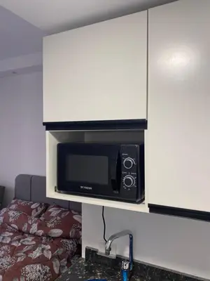 a microwave on a cabinet above a kitchen counter at Florenza01 in Hurghada
