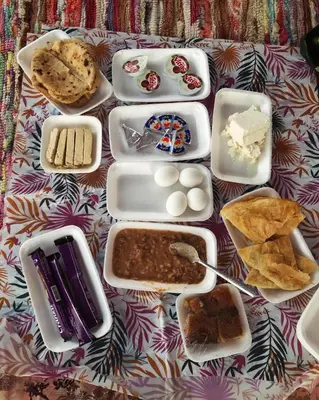 a table topped with trays of food on a table at Anoosh camp in Aswan