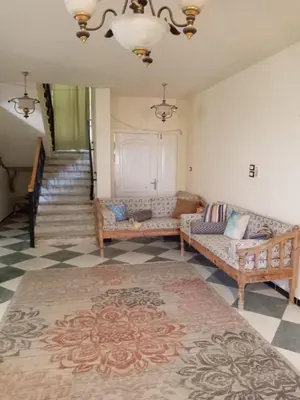a living room with two couches and a staircase at Al-Kiam Villa A F in Hurghada