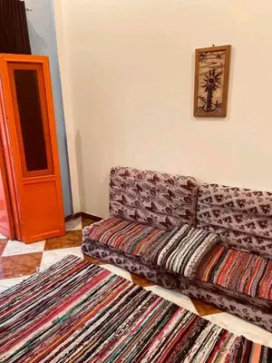 a living room with a couch and some rugs at Noury kato in Jazīrat ‘Awwāḑ