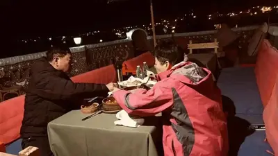 a man and woman sitting at a table at night at Noury kato in Jazīrat ‘Awwāḑ