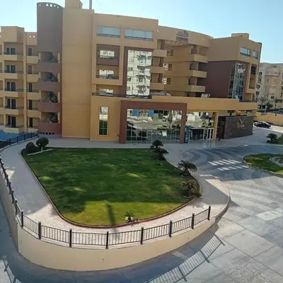 an apartment complex with a lawn in front of a building at Tiba Golden -unit102 - Aladauy in Hurghada