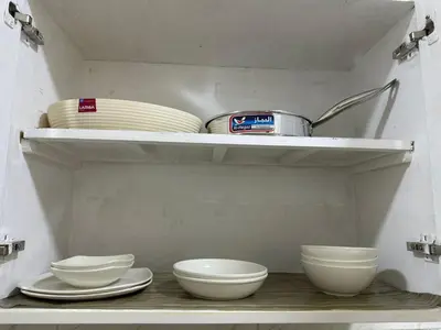 a shelf with white bowls and plates on it at TibaHouse in Luxor