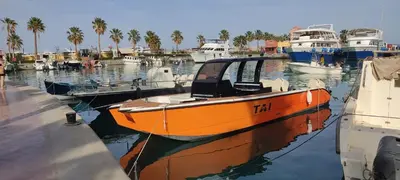 an orange boat is docked in a harbor at Tai Speedboat orange bay Island- Paradis Island- Dolphin - hula hula Island - Magawish island-etc in Hurghada