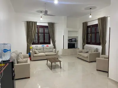 a living room with couches and a table in it at Al-Fardous house in Luxor