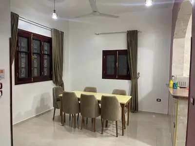 a dining room with a table and chairs at Al-Fardous house in Luxor