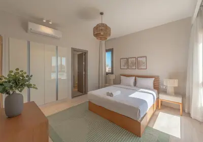 a bedroom with a large bed and a potted plant at Ancient Hill 3BR Gouna Sea View & Priv Roof Pool in El Gouna
