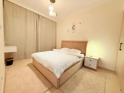 a white bedroom with a bed and a night stand at شقه فندقية متكامله 1 غرفه غايه فى الروعه والهدوء hurghada in Hurghada