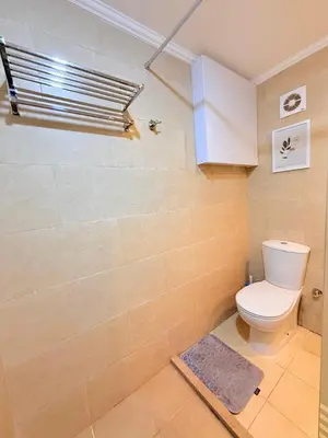 a bathroom with a toilet and a tile wall at شقه فندقية متكامله 1 غرفه غايه فى الروعه والهدوء hurghada in Hurghada