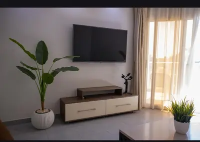 a living room with a tv on a wall with a plant at Scandic Resort Hurghada in Hurghada