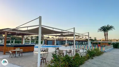 a patio with tables and chairs and a pool at Scandic Resort Hurghada in Hurghada