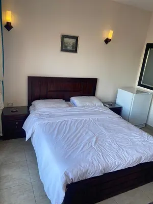 a large bed in a bedroom with two night stands at Mirage bay resort in Hurghada