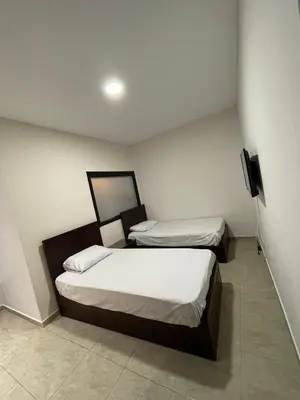 a room with two beds and a television in it at Mirage bay resort in Hurghada