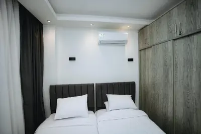 a bedroom with two beds and a wooden headboard at Selina Bay Resort in El Gouna
