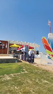 a group of umbrellas and tables on a beach at Selina Bay Resort in El Gouna