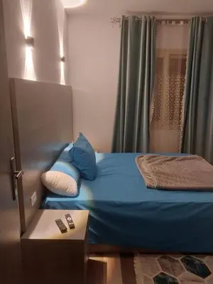 a bed with blue sheets and pillows in a room at Royal residence in Marsa Alam