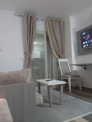 a living room with a couch and a table and a tv at Royal residence in Marsa Alam