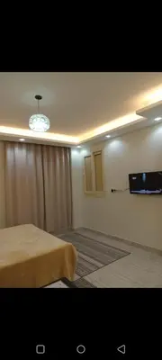 a room with a bed and a television on a wall at Enter compound in Hurghada
