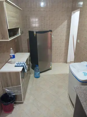 a kitchen with a refrigerator in the middle of a room at Eslam apartment 2 in Hurghada
