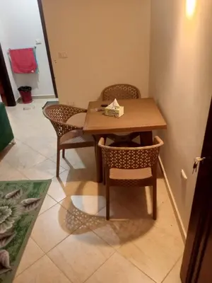 a wooden table and chairs in a room at Eslam apartment 2 in Hurghada