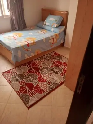 a bedroom with a bed and a rug on the floor at Eslam Apartments in Hurghada