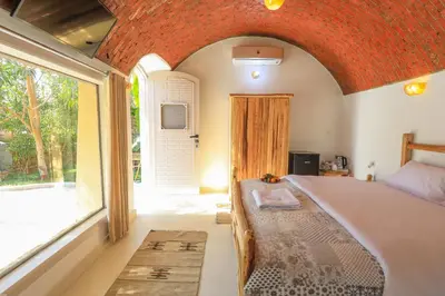 a bedroom with a large bed and a large window at Eden on the Nile in Luxor