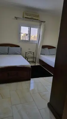 a bedroom with two beds and a window at Paradise Hill in Hurghada
