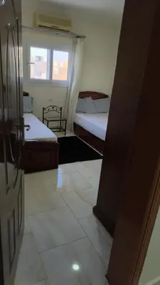 a small bedroom with two beds and a window at Paradise Hill in Hurghada