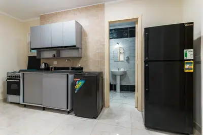 a kitchen with a black refrigerator and a sink at Luxury City Center One-Bedroom Suite by Peaks in Hurghada